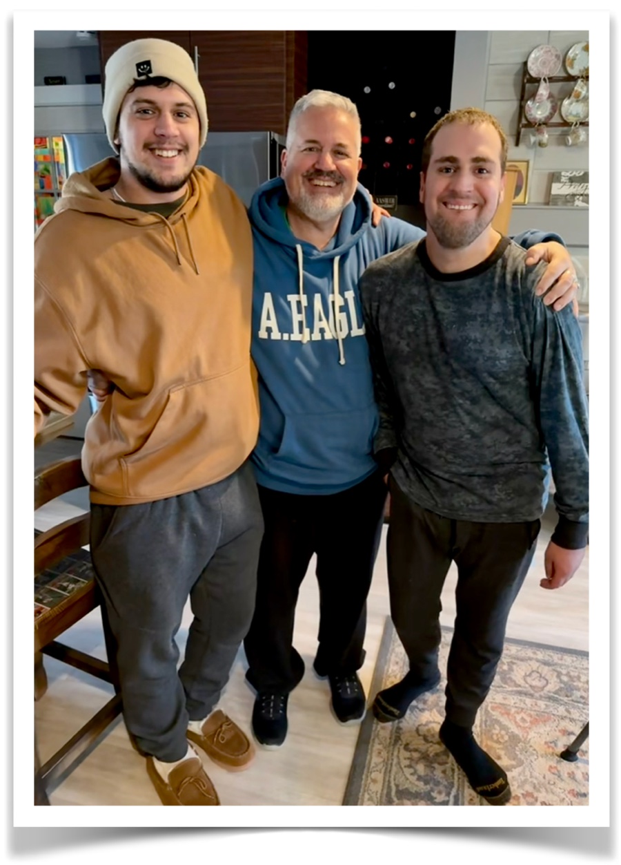 Joshua, Rob and Nicholas LiPuma, smiling together in the kitchen